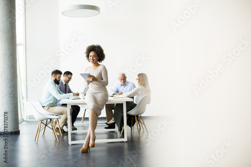 Smiling African woman using a tablet in office