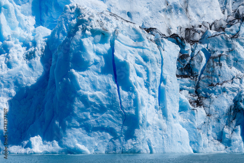 Plakat Język Glaciar Spegazzini odbijający niebieskie i purpurowe światło w głębokich pęknięciach w lodzie