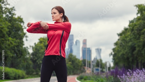 Zdjęcie XXL młody biegacz dziewczyna fitness rozciąga ramiona przed uruchomieniem w mieście