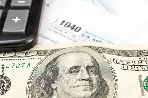 Tax form with calculator and money. Close up. Business concept.