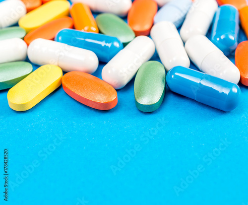 Different pills on a blue background. Medical background.