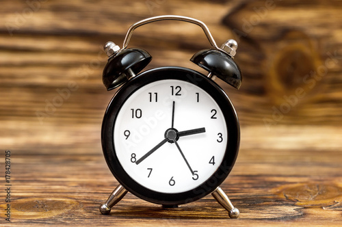 Alarm clock on the wooden background. Close up.