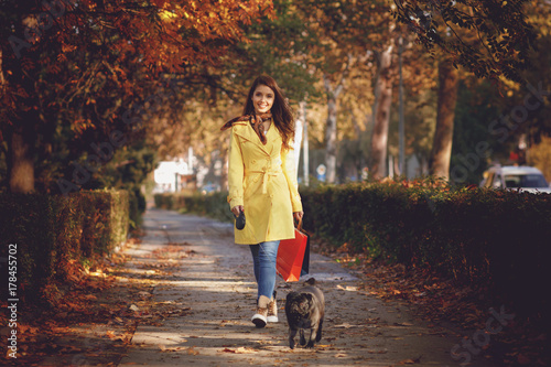 Young woman walking with a dog after shopping