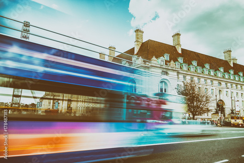 LONDON - SEPTEMBER 25, 2016: Colourul bus speeds up along Westminster Bridge. London attracts 30 million tourists annually
