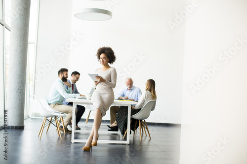 Smiling African woman using a tablet in office