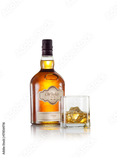 close up view of glass with ice and whiskey and a bottle aside. self made label.