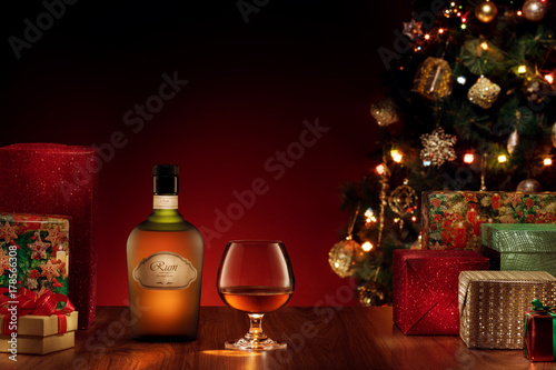 close up view  of bottle and glass with rum on color back. self made label.