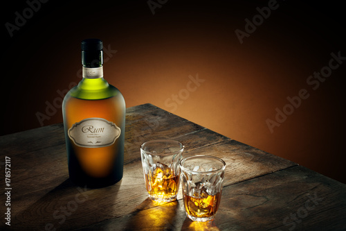 view of glasses of  rum and a bottle aside on color background. self made label.