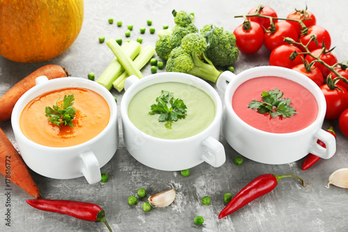 Vegetable cream soup with parsley on grey wooden table