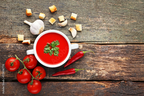 Tomato soup with parsley on grey wooden table