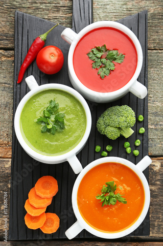 Vegetable cream soup with parsley on black cutting board