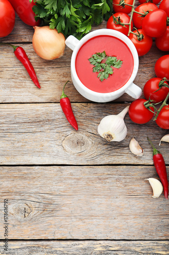 Tomato soup with parsley on grey wooden table