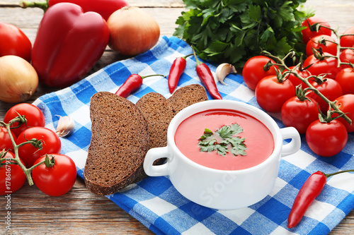 Tomato soup with parsley on grey wooden table
