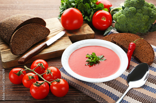 Tomato soup with parsley on wooden table