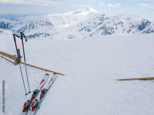Snow covered mountains and alpine skis on a foreground