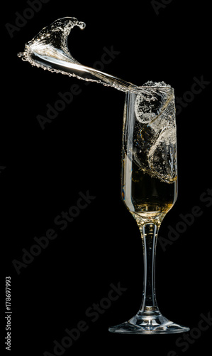 Glass of champagne with splashes on a black background
