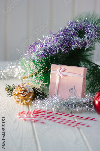 Box with christmas gifts and presents on white wooden board.