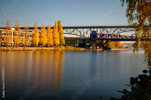 Fall colors and golden aspen trees along a bike path and water with bridges