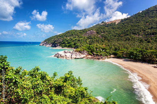 Tropical beach and hills covered with palm trees, view from the top