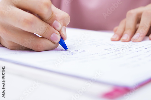 child's hand writing on the home desk or school