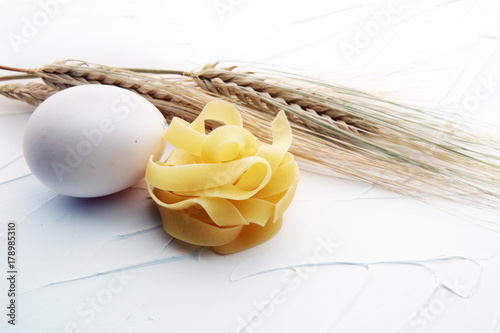 traditional italian homemade pasta with ingredients on white background.