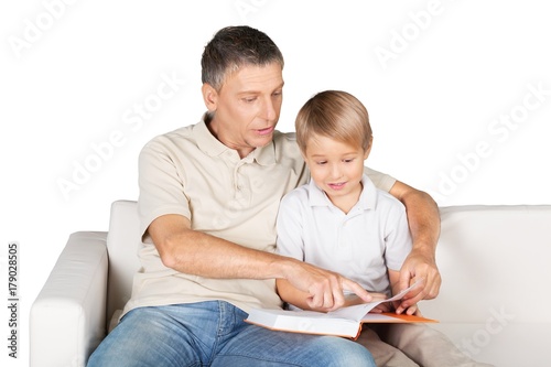 Father and Son Reading a Book on the Couch