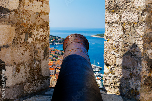 Cannon on the fortress known as Fortica with aerial view of harbor on island Hvar, Croatia