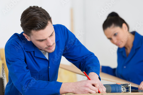 carpentary students training at the workshop measuring woodboard
