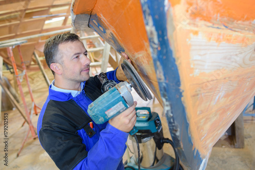 worker using a power sander