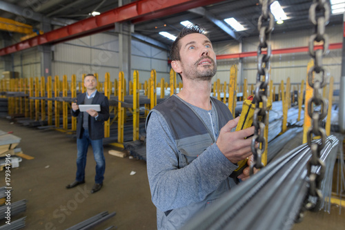 Man controlling hoist in factory