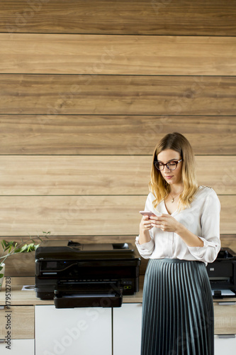 Young businesswoman with mobile phone in office