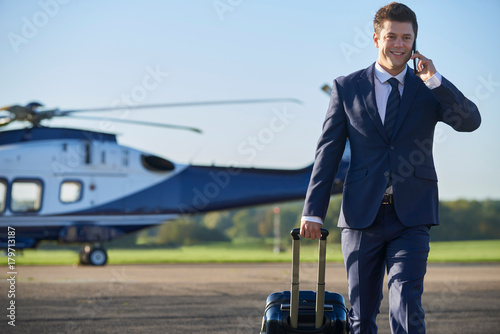 Zdjęcie XXL Biznesmen spaceru od helikoptera podczas rozmowy na telefon komórkowy