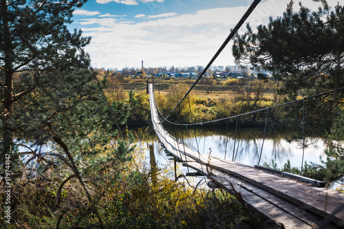Fototapeta Bridge over the river and the autumn nature around