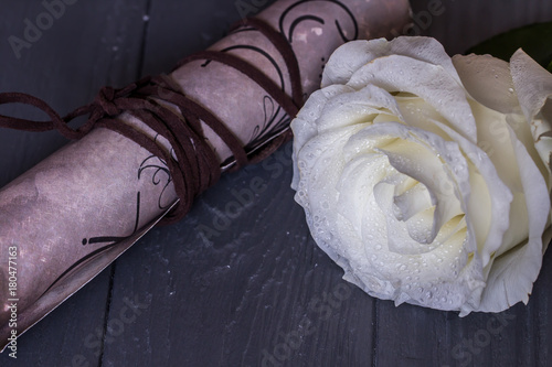 Fototapeta Beautiful white rose with love letter in scroll on the wooden background