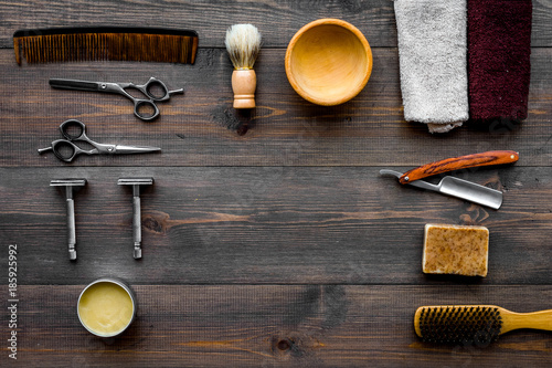 Vintage barbershop tools. Razor, sciccors, brush on dark wooden background top view pattern copyspace © 9dreamstudio