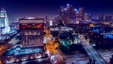 Cinematic urban aerial view of downtown streets with city skyline at night