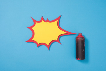 top view of spray paint in can and empty paper speech bubble isolated on blue