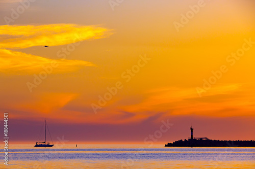 Plakat Lato jasny pomarańczowy zachód słońca z helikoptera w chmurach i sylwetka żaglowca obok latarni morskiej na brzegu. Nabrzeżny seascape na Czarnym morzu, Sochi, Rosja.