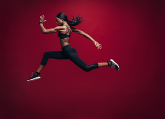 Female athlete running and jumping