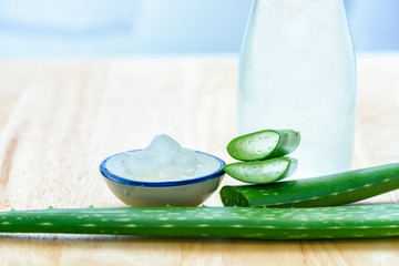 Fresh aloe vera leaves with aloe vera juice in bottle on wooden