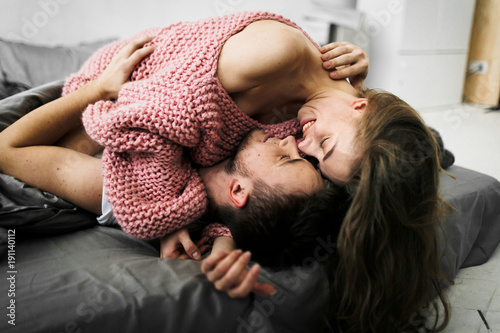 Sensual romantic foreplay by couple in love in bed. Arrwork.