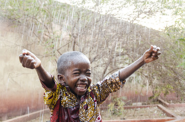 Water is coming! African ethnicity little boy happy to finally get some rain