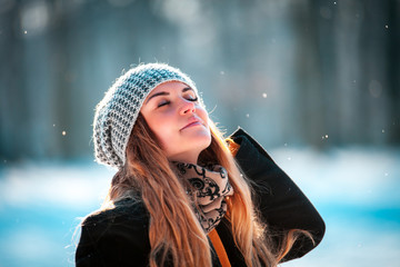 Young woman walking in winter park at sunny day