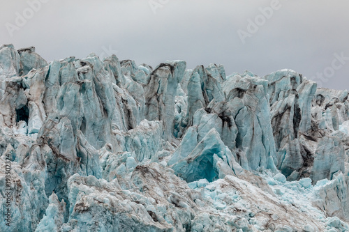 Plakat Zbliżenie lodu lodowca. Błękitny lód z chmurnym niebem above. Svalbard, Spitsbergen