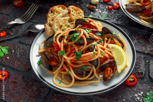 Fotoobraz na płótnie Domowej roboty makaronu spaghetti z mussels, pomidorowym kumberlandem, chili i pietruszką na nieociosanym tle ,. posiłek z owocami morza