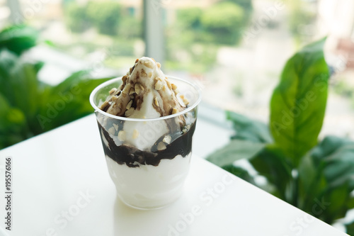 Plakat Lody Sundae z czekoladą i orzechem włoskim na plastikowym szkle na bielu stole
