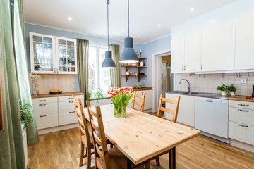 kitchen interior with green curtains by the window tulips on the kitchen table