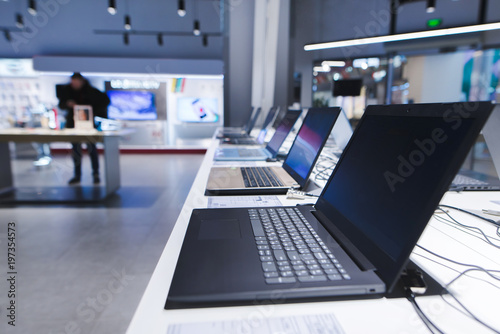 Zdjęcie XXL Laptopy na stole w sklepie elektronicznym. Dział laptopów w sklepie tech. Kup laptopa