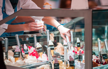 Woman behind counter serving ice cream