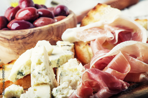 Plakat Przekąski lub antipasti, crostini, prosciutto, ser pleśniowy i oliwki, szare tło, selektywne focus